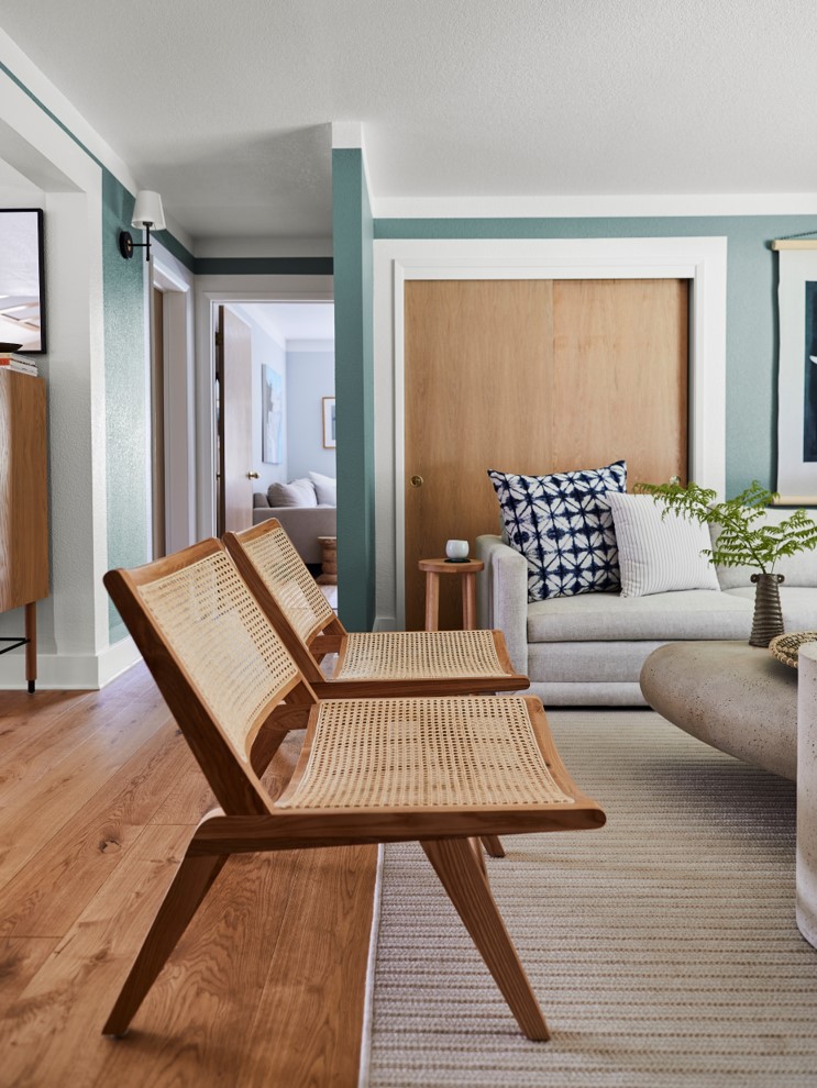 Living room with teal walls and light oak hardwood floors
